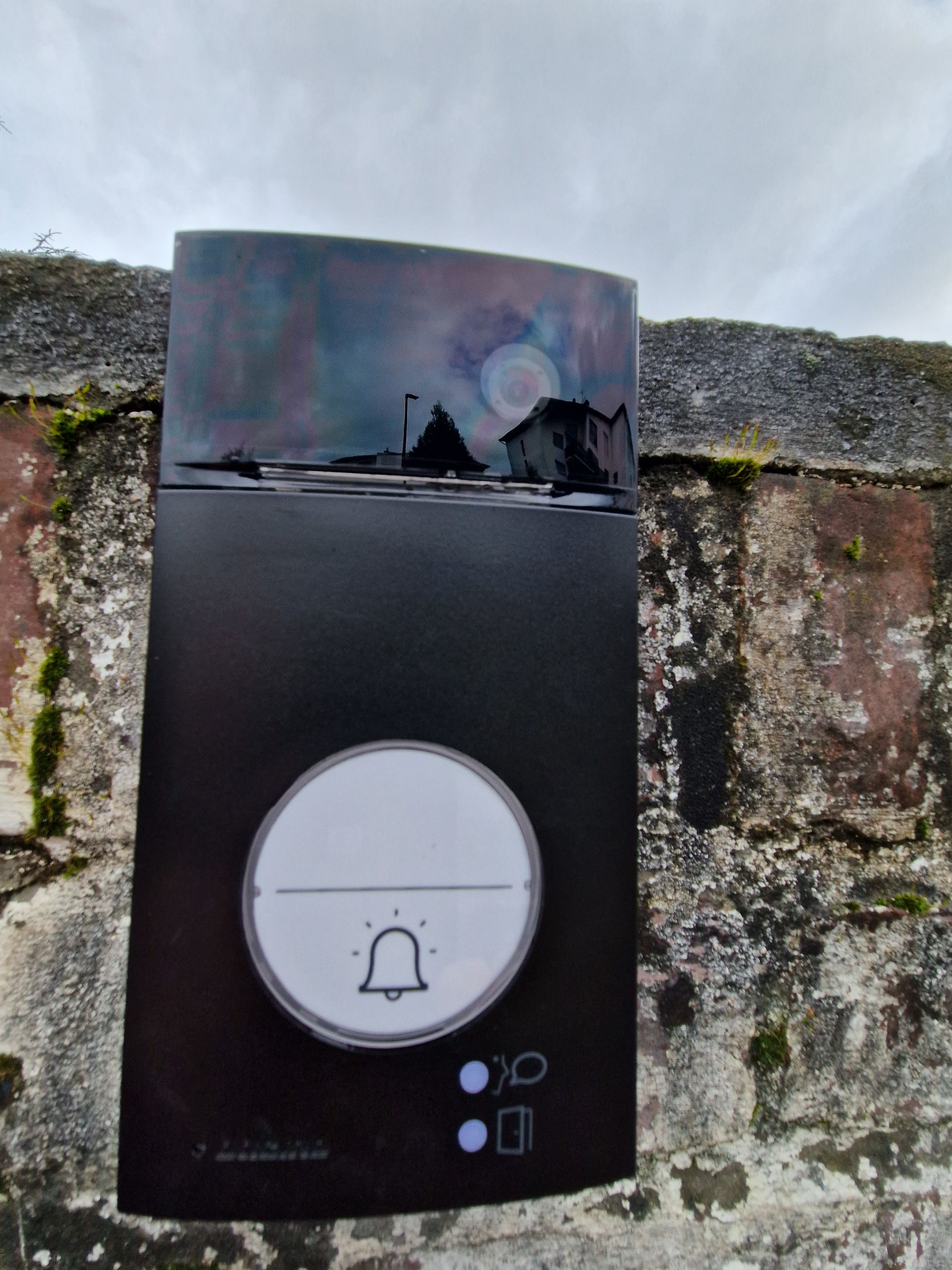 Un interphone noir sur un mur extérieur
