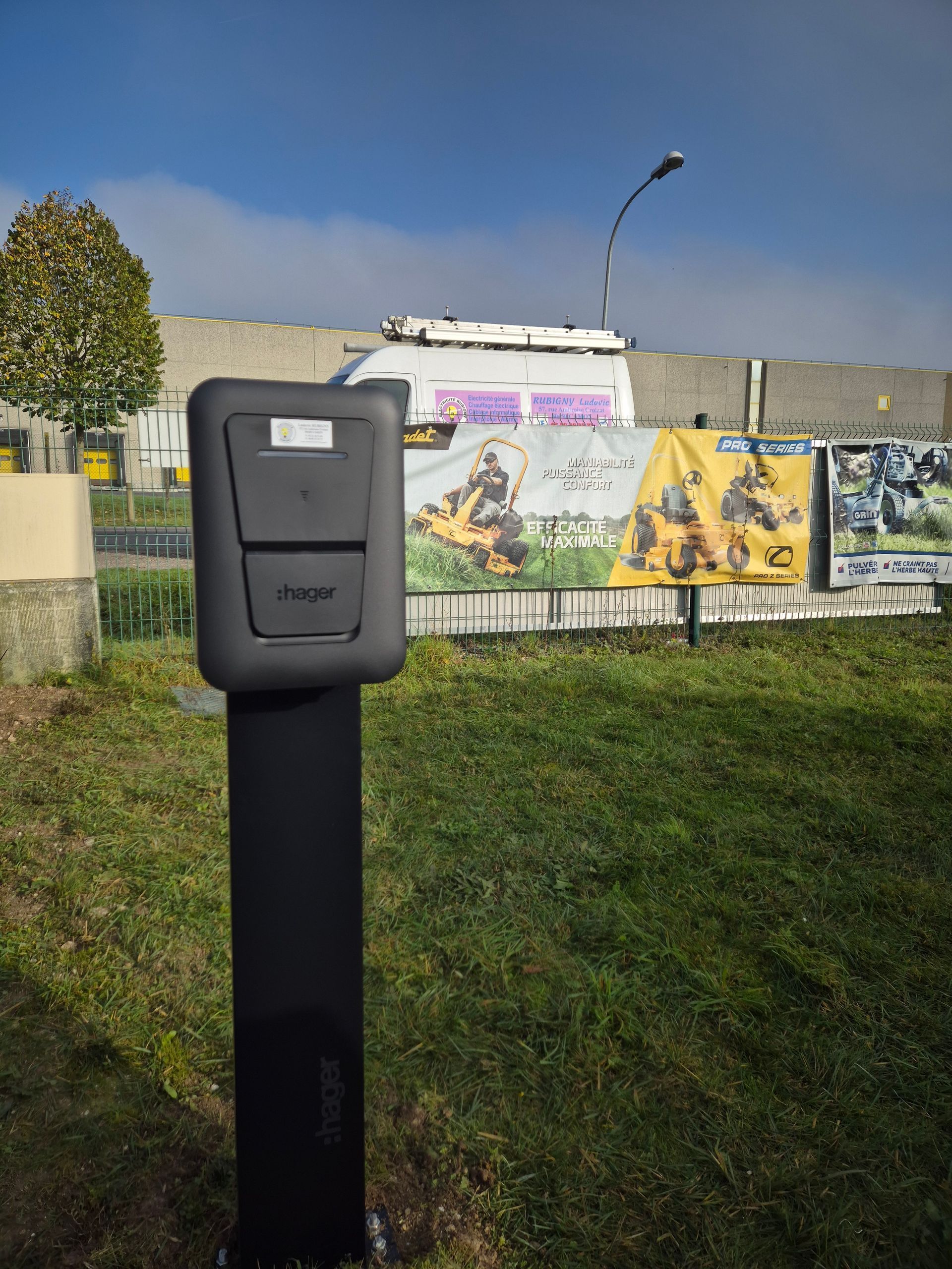 Une borne de recharge noire avec un gazon en arrière-plan