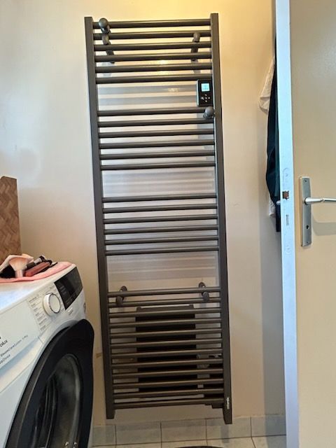 Un sèche-serviettes près d'un lave-linge