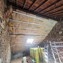 Un mur en pierres anciennes en travaux d'isolation.