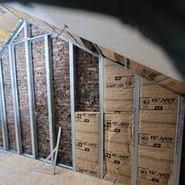 Un mur en pierre en travaux d'isolation.