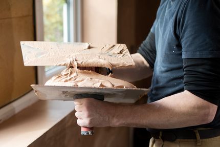 Une personne avec des outils de plâtrerie.