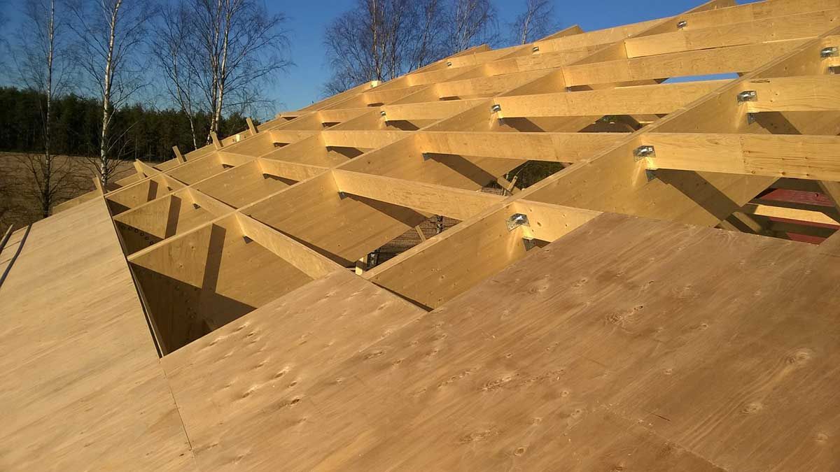 Puinen geometrinen kiipeilyrakennelma, jossa on kolmionmuotoiset aukot aurinkoisessa ulkopuistossa