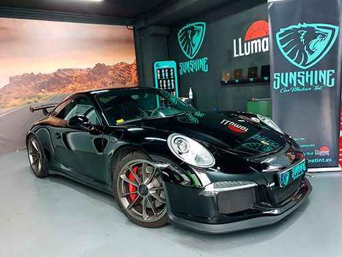 Un Porsche 911 GT3 RS negro está aparcado en un garaje.