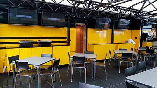 Hay muchas mesas y sillas en la habitación.