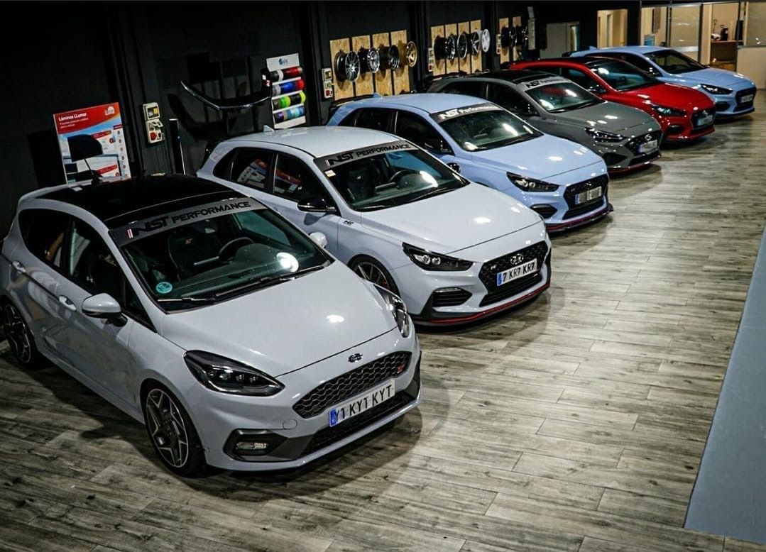 Una fila de coches están aparcados en una sala de exposición.