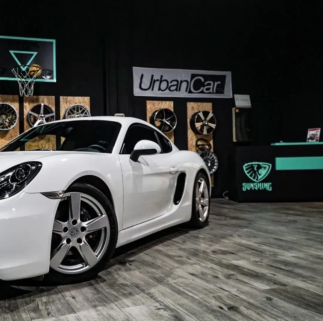 Un coche negro está aparcado delante de una pared de ruedas.
