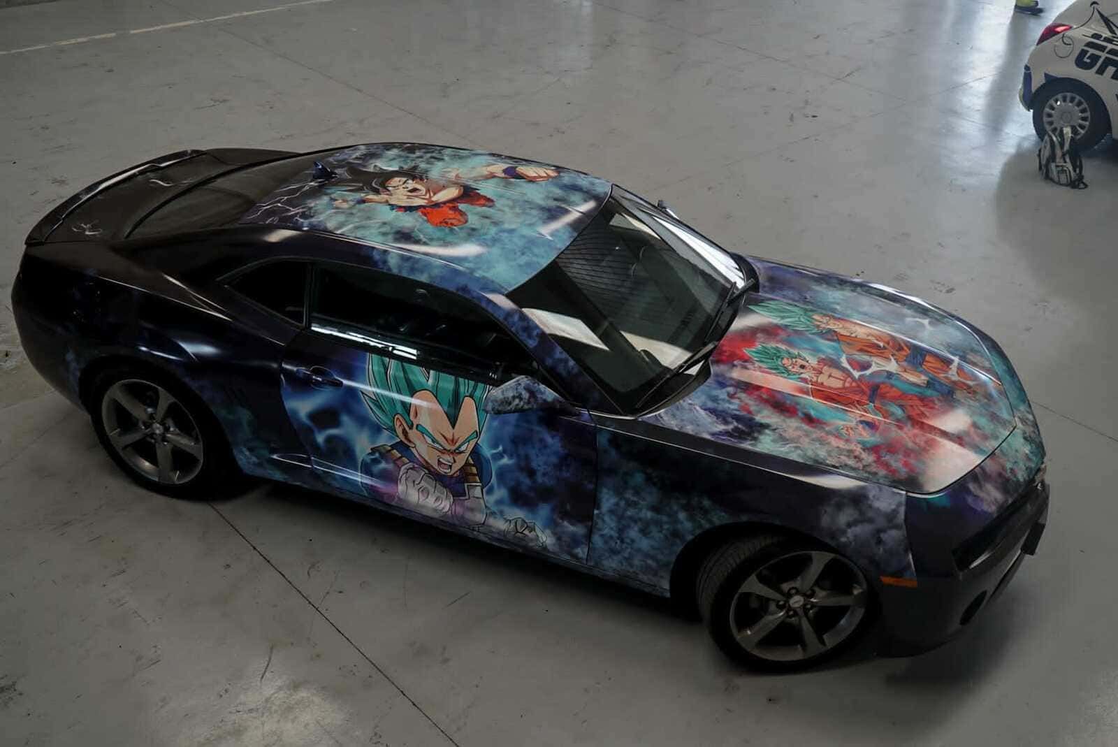 Un automóvil con un diseño de Dragon Ball Z está estacionado en un garaje.