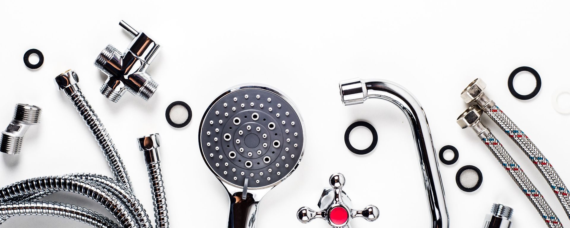 Assortiment de robinetterie et de flexibles de douche chromés sur fond blanc.