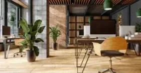 A modern office with wooden floors , desks , chairs and a computer.