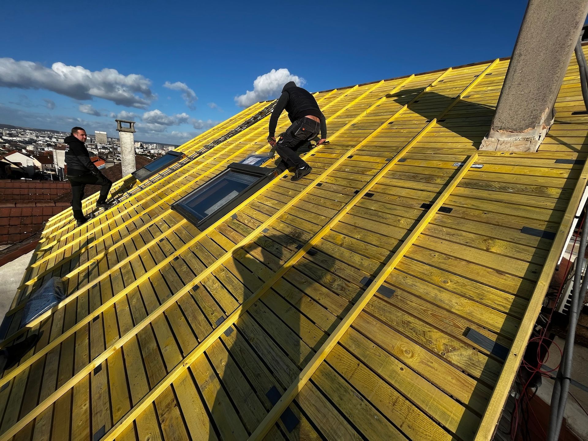 deux ouvriers de FF toiture en train de travailler sur un toit