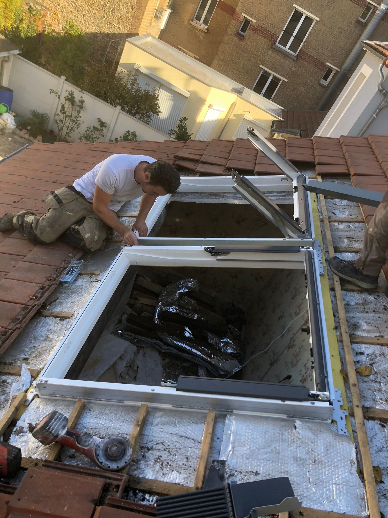 Deux ouvriers créent une ouvertures pour poser des fenêtres de toit