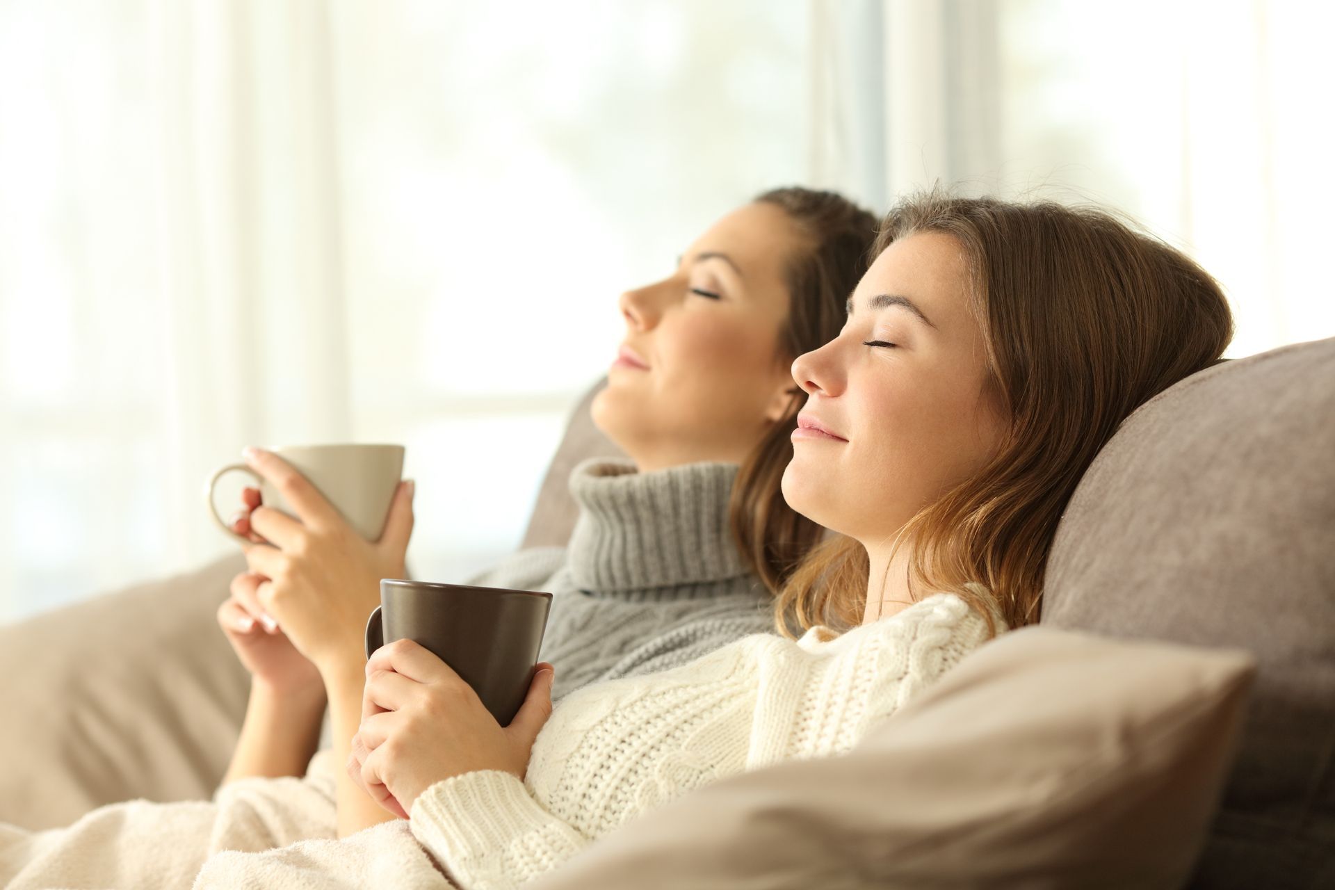 Deux femmes boivent un thé relax sans avoir froid car leur maison est bien isolée