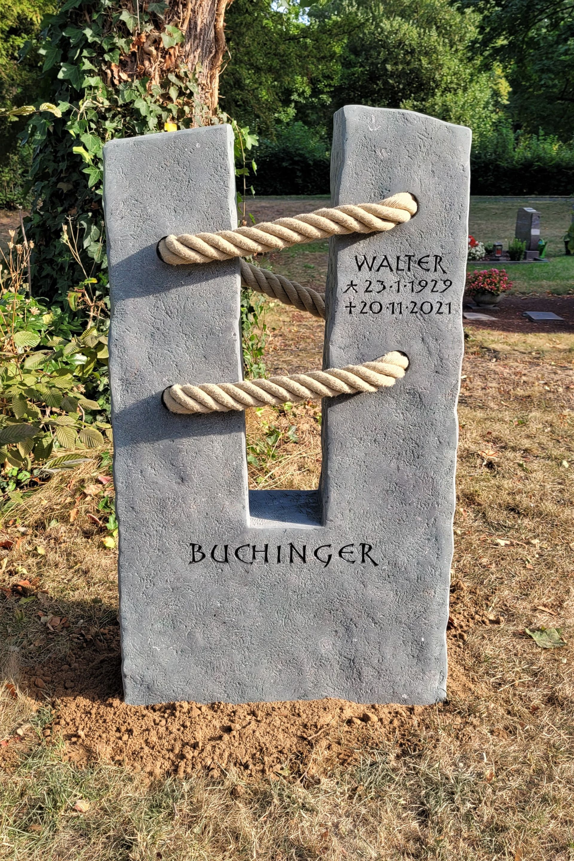 Eine Skulptur mit einem Seil darum auf einem Friedhof