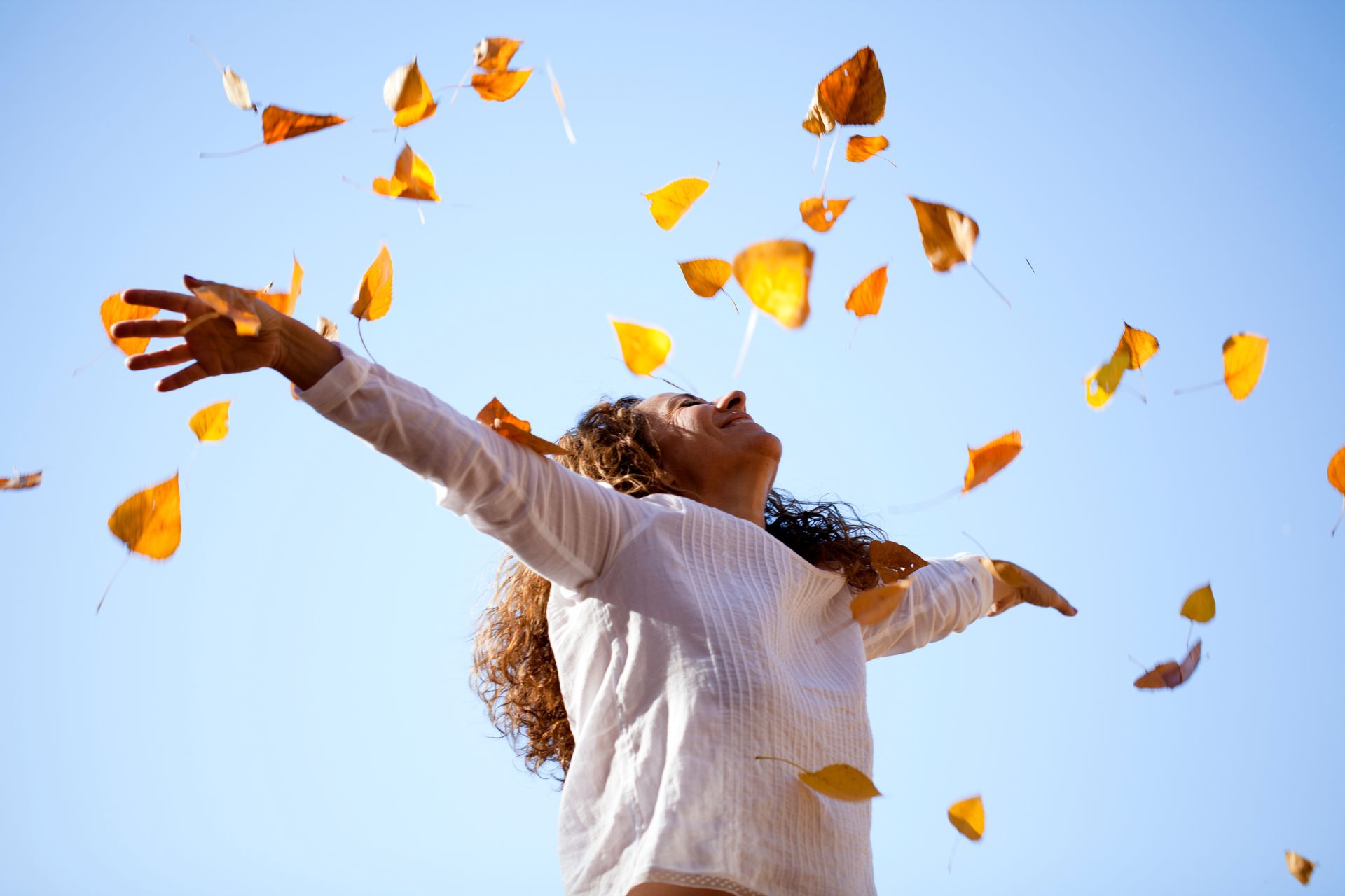 Femme qui s'amuse avec des feuilles