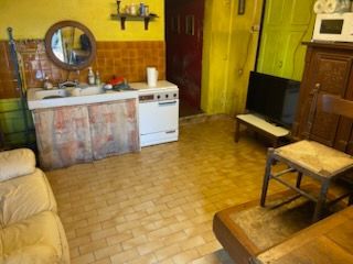Pièce encombrée de déchets, de cartons et de sacs en papier éparpillés, avec des étagères le long des murs.