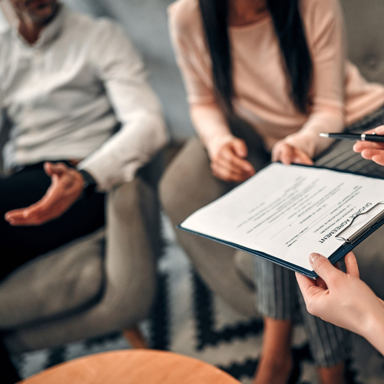 Un couple en thérapie avec un thérapeute tenant un document.