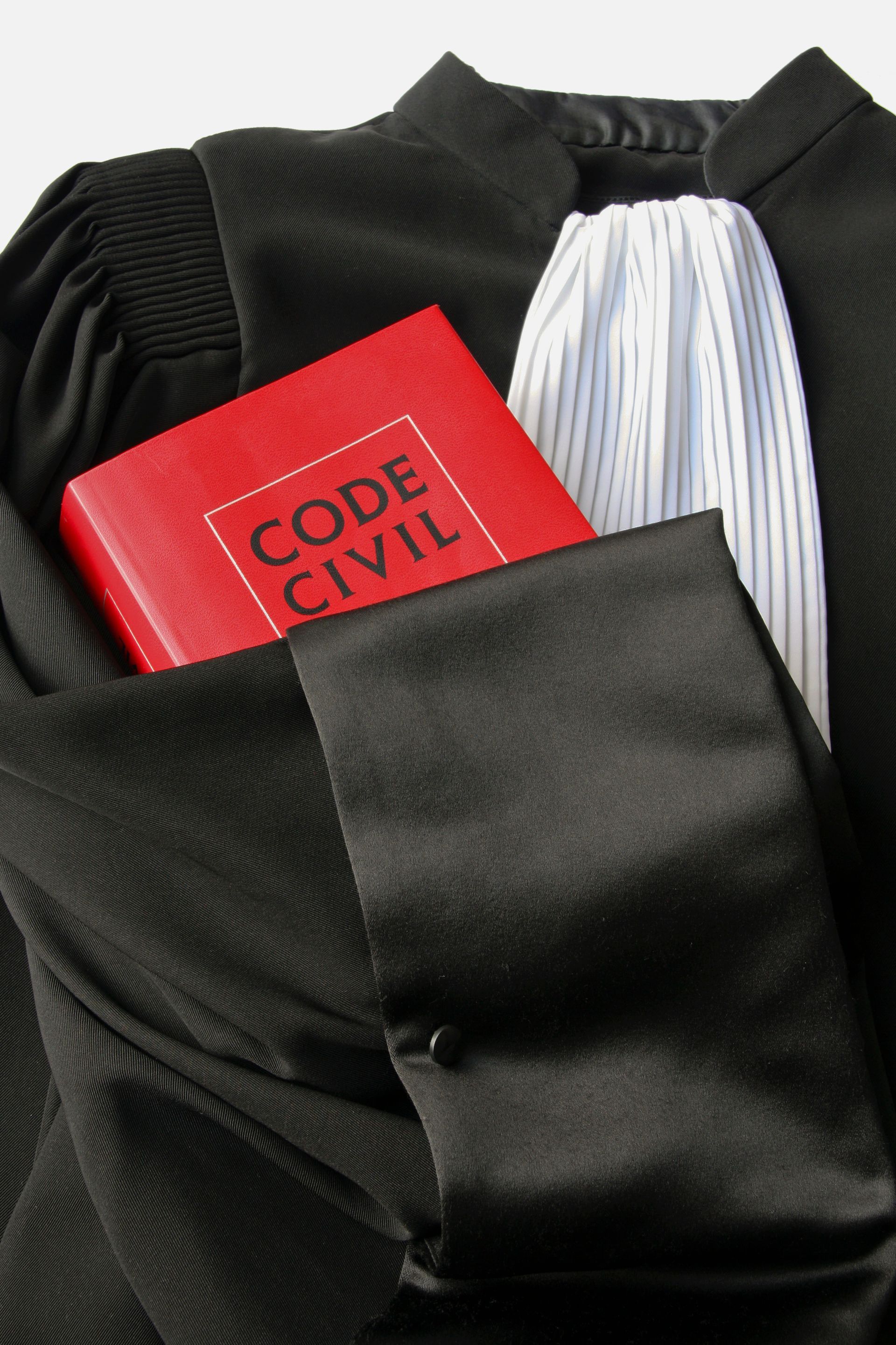 Code civil sous la manche d'une robe d'avocat.