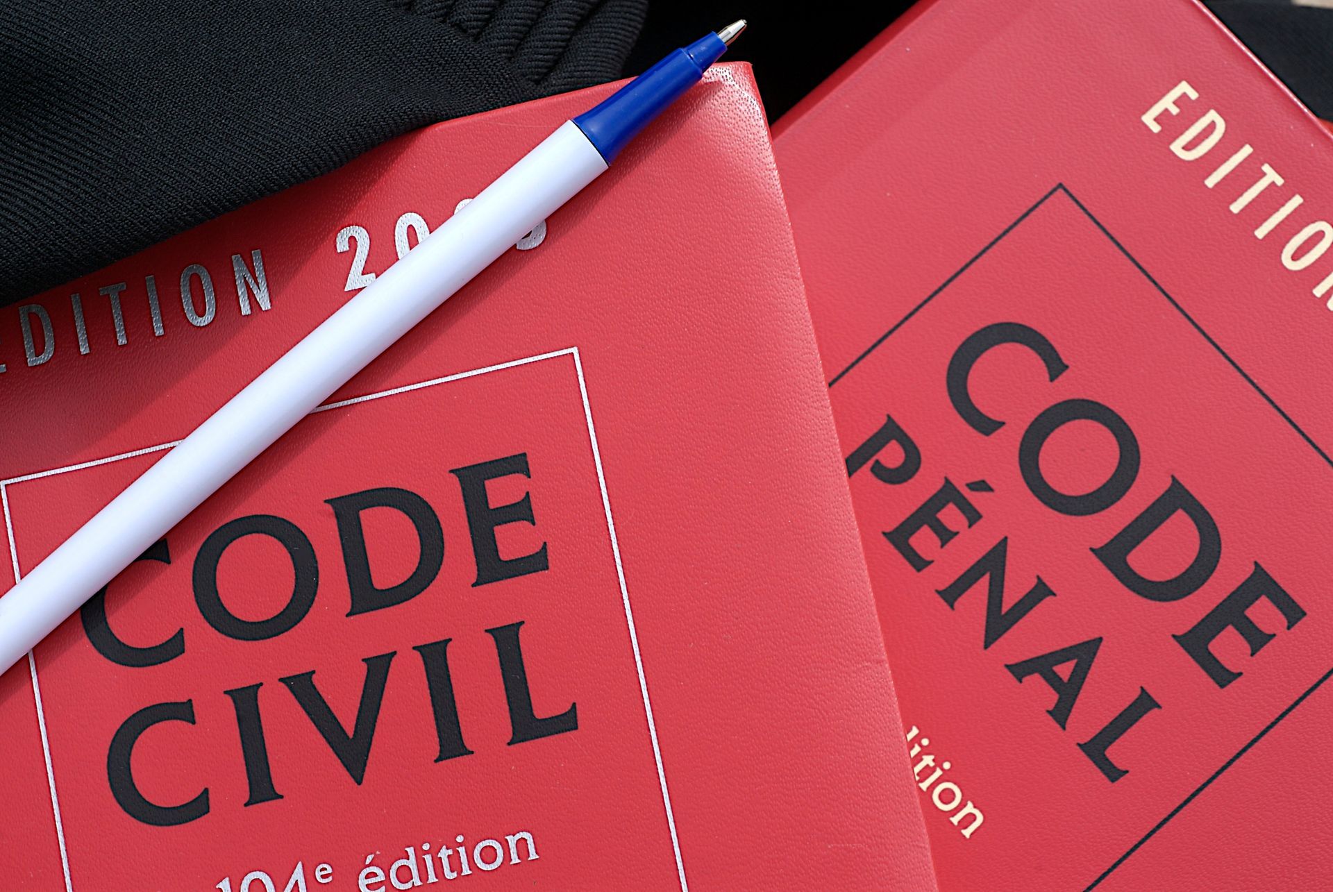 Code civil et code pénal avec un crayon.