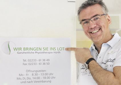 Ein Mann zeigt auf ein Schild mit der Aufschrift „Wir bringen Sie ins Lot“.
