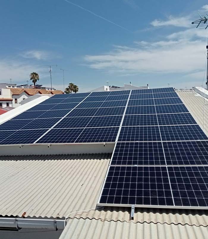 Paneles solares instalados en un tejado contra un cielo azul, generando energía renovable.
