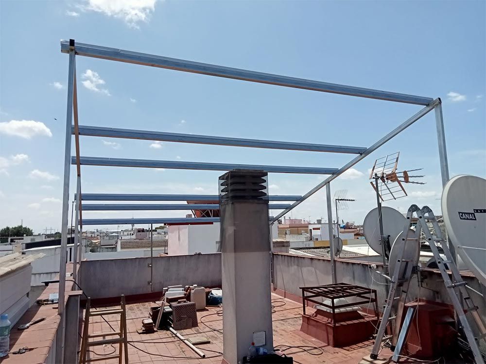 Estructura metálica en la azotea bajo un cielo azul. Antenas y antenas parabólicas.