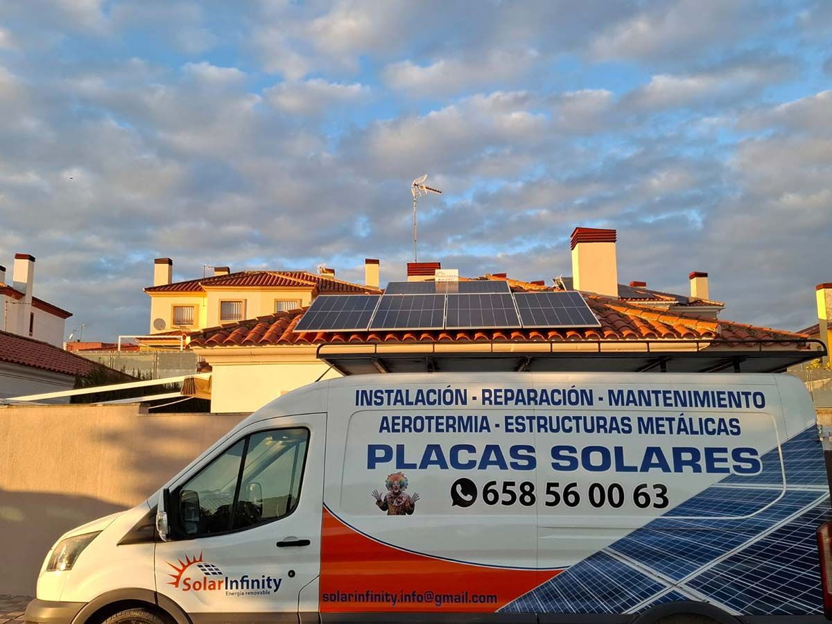 Furgoneta con anuncio de paneles solares estacionada cerca de un techo con paneles solares contra un cielo nublado.