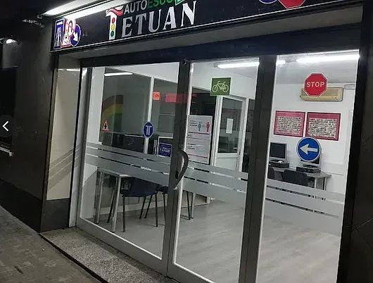 Una tienda con puertas corredizas de vidrio y una señal de pare en la pared.