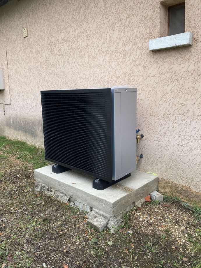 Un bloc de pompe à chaleur avec une petite fenêtre à droite