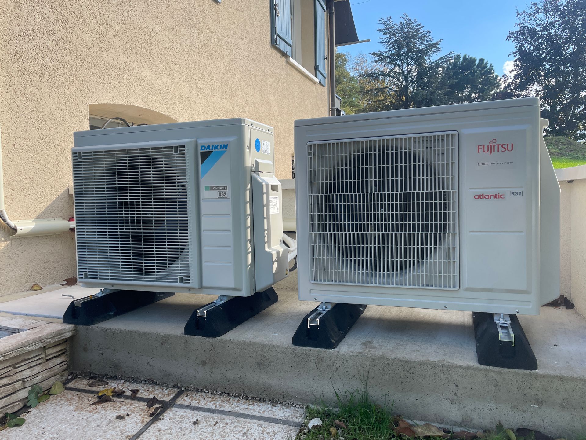 Deux blocs extérieurs de climatisation à côté d'une maison