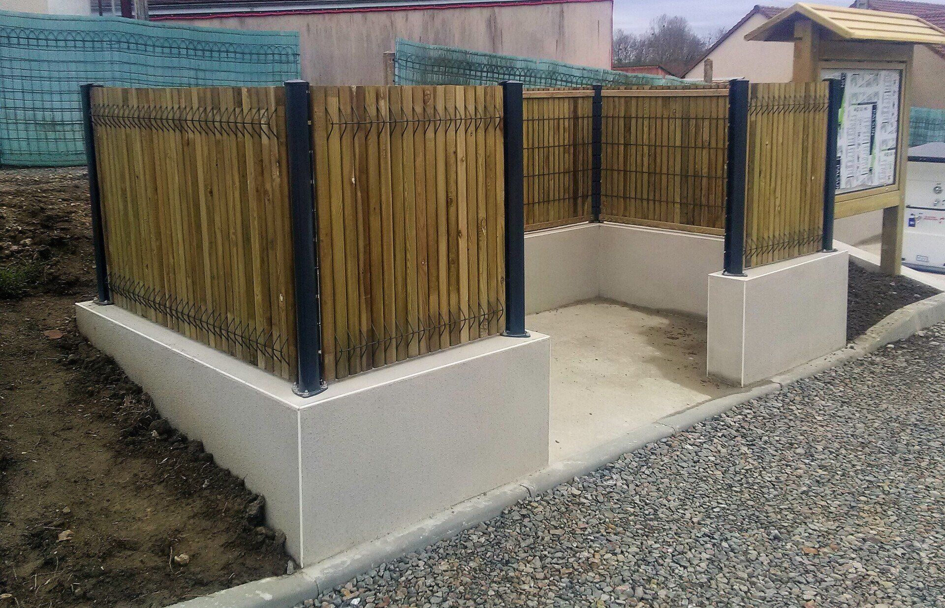 Une petite clôture pleine entourant un petit espace pour le protéger des regards