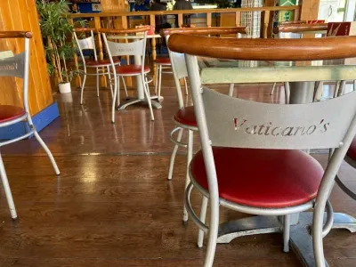 Un restaurante con mesas y sillas y una silla que dice Vaticano.