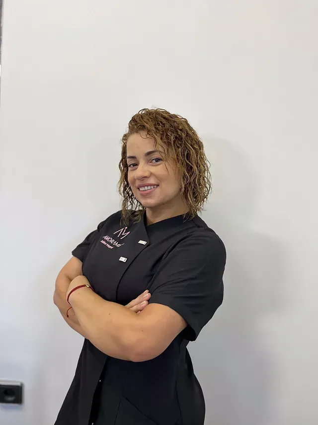 Una mujer con uniforme negro posa para una fotografía con los brazos cruzados.
