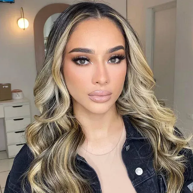 Una mujer con cabello largo y rubio lleva una chaqueta vaquera negra.