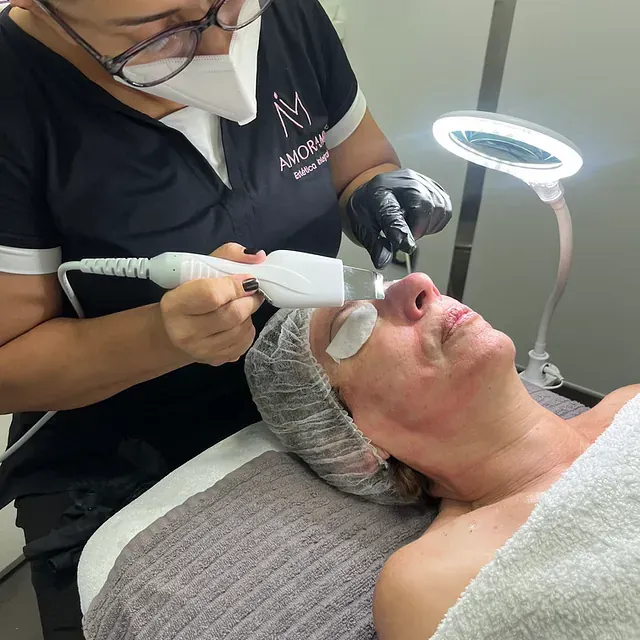 Una mujer se trenza el cabello frente a un espejo.