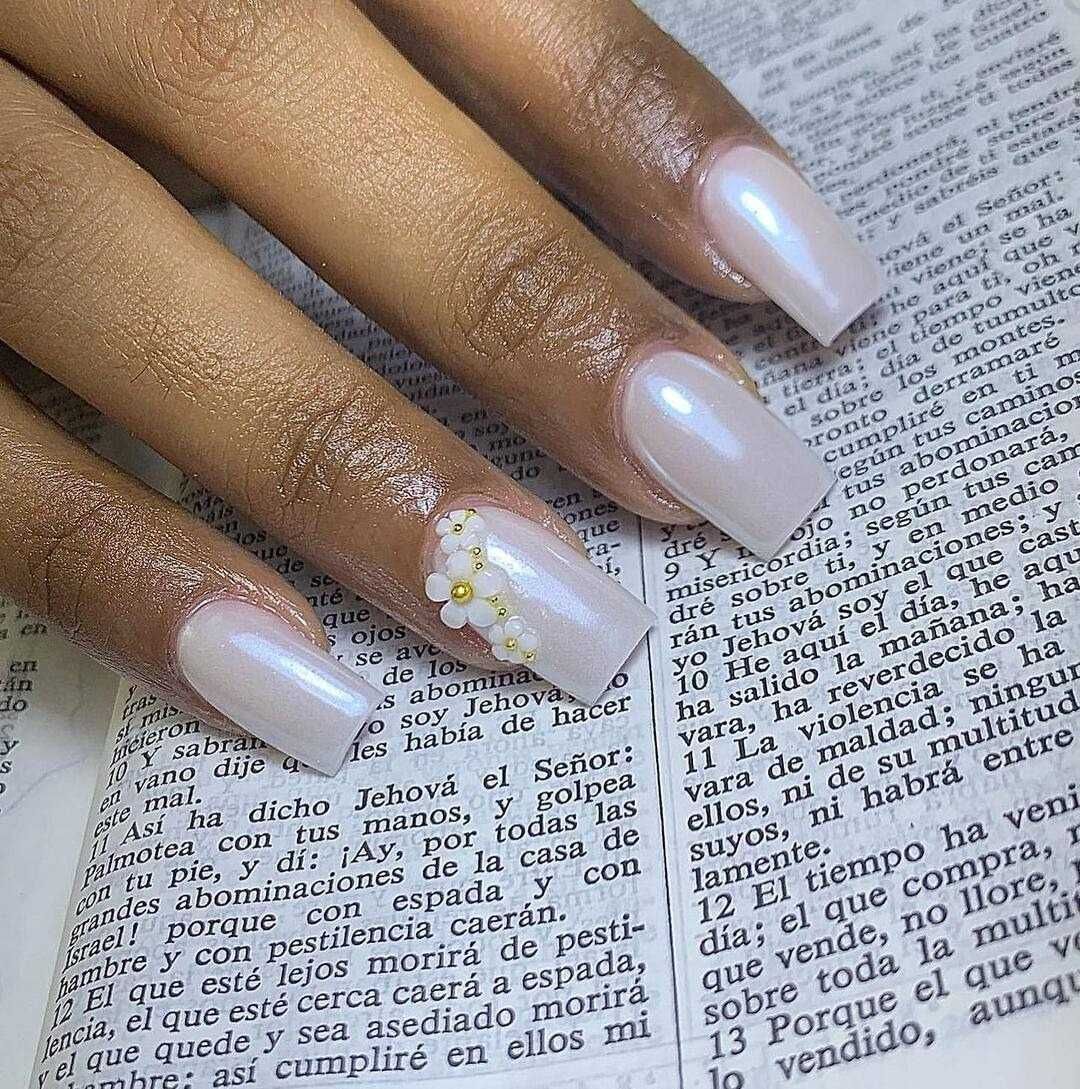 Un primer plano de las uñas de una mujer encima de una Biblia.
