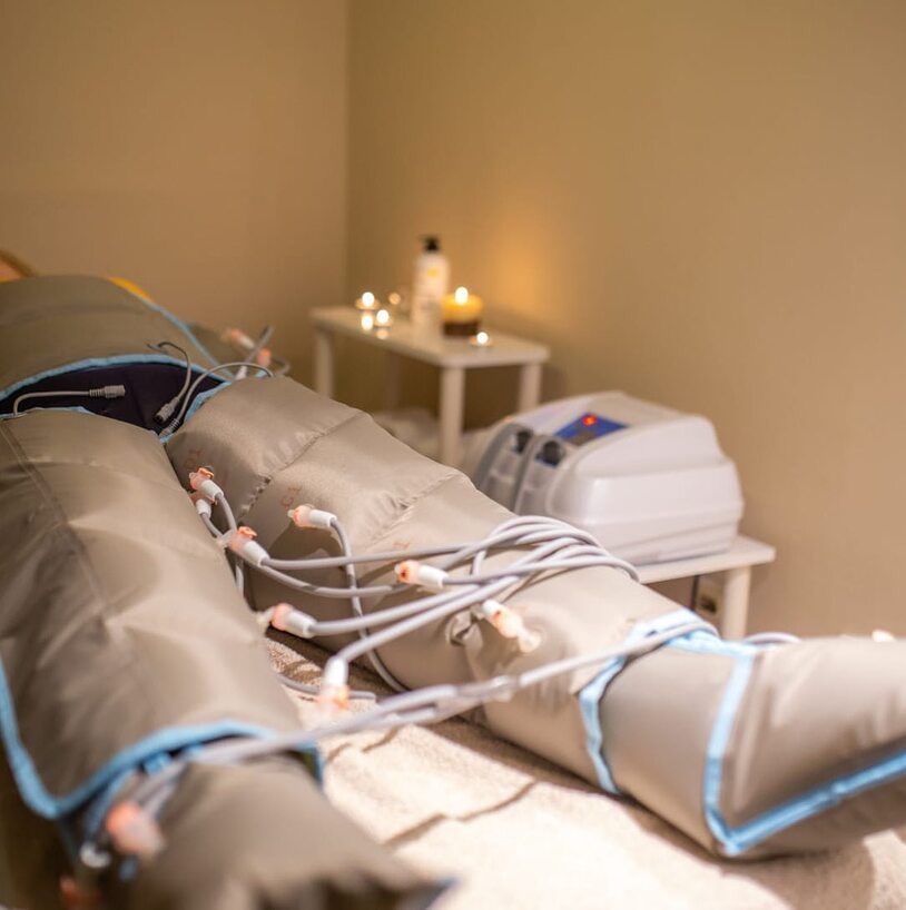 Una persona está acostada en una cama con una máquina en sus piernas.