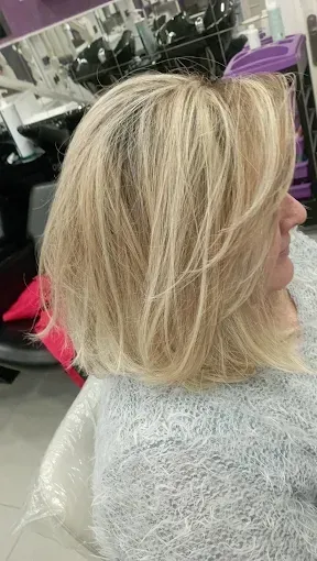 Corte bob rubio a capas en peluquería, perfil lateral, con ondas suaves y reflejos claros.