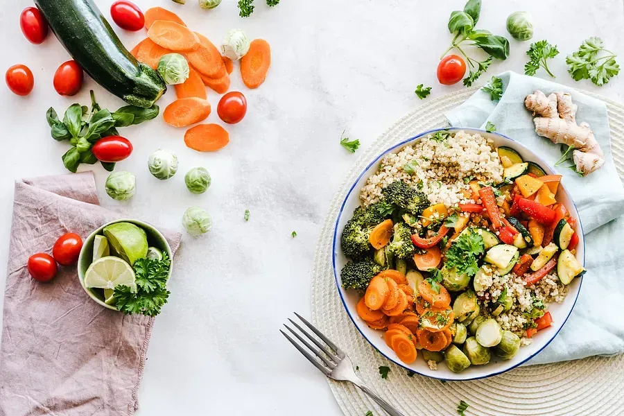 Un plato de verduras y arroz sobre una mesa con un tenedor.