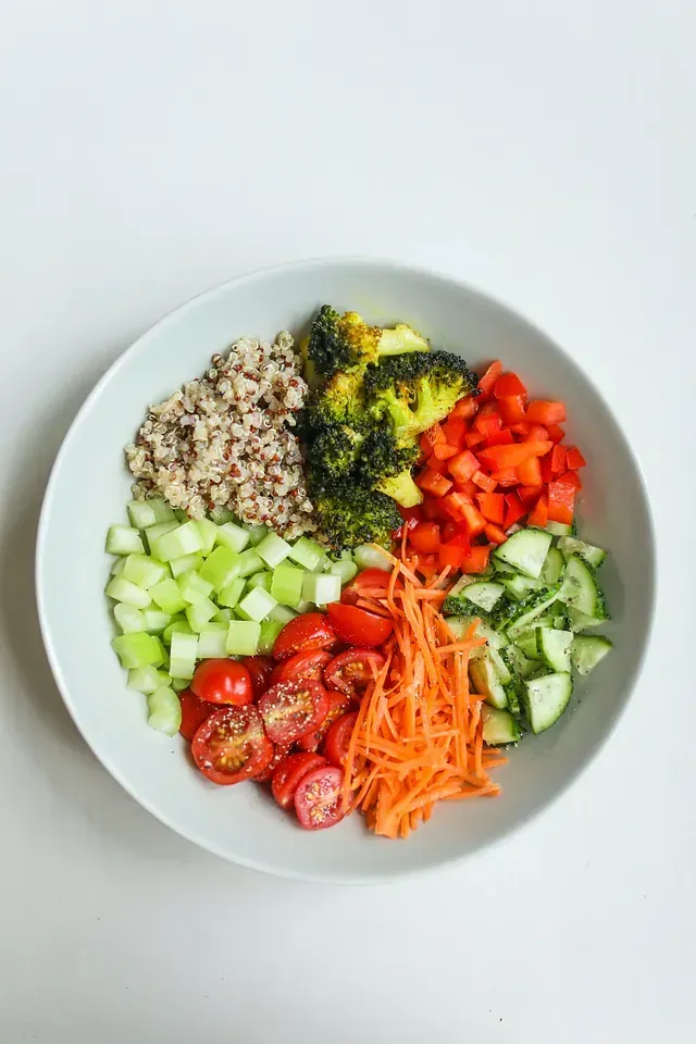 Un recipiente lleno de verduras y arroz sobre una mesa.