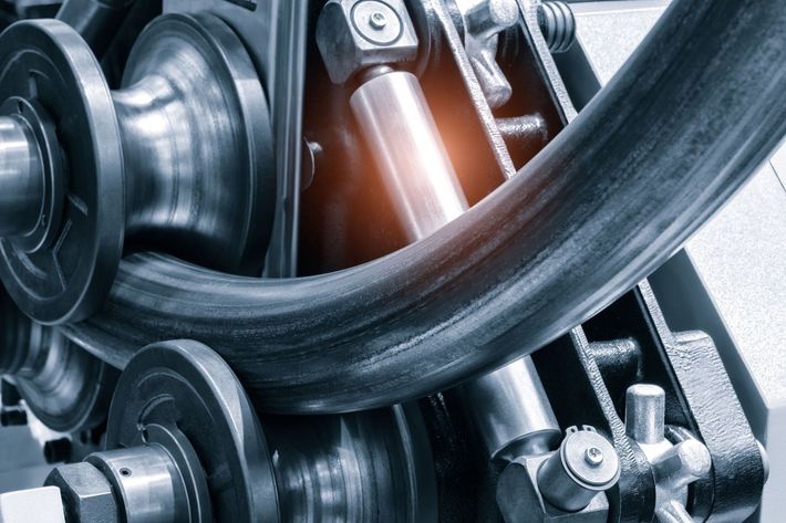 Un primer plano de un tubo de metal que se enrolla en una máquina.