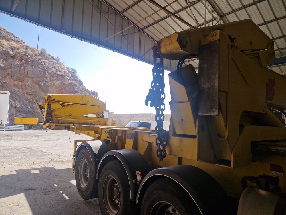 Un gran camión amarillo está estacionado bajo un techo.