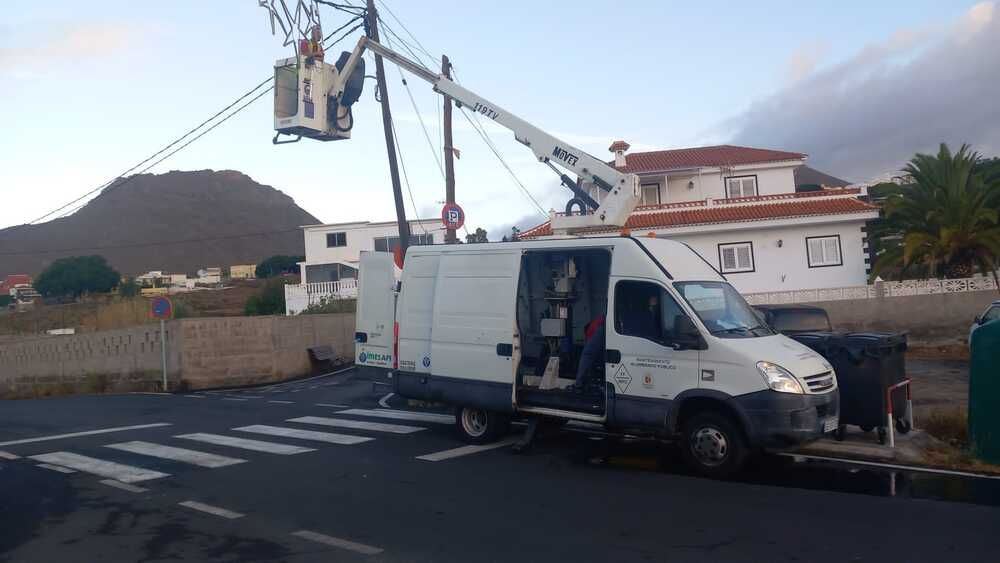 Una camioneta blanca está estacionada al costado de la carretera.