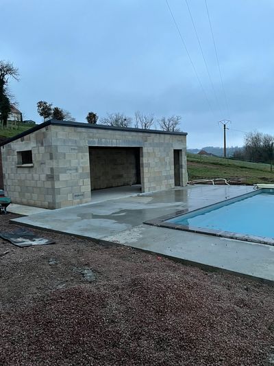 Petit bâtiment en béton à côté d'une piscine par temps couvert