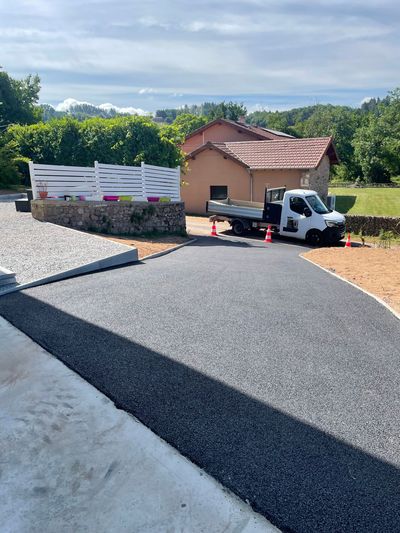 Petit camion garé près d'une maison sur une allée de gravier sous un ciel ensoleillé