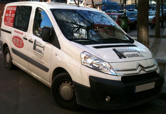 Una camioneta blanca está estacionada al costado de la carretera