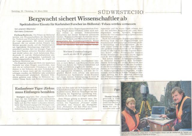 Zeitungsartikel. Bergwacht sichert Wissenschaftler. Foto von zwei Personen mit Ausrüstung im Freien, in Westen, in der Nähe eines Berges.