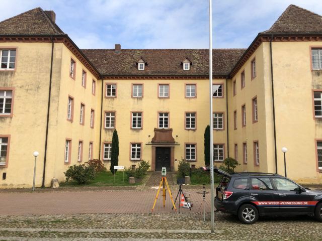 Mit rosa und grüner Sprühfarbe markierte Holzpfähle, die für den Bau im Freien verwendet werden.