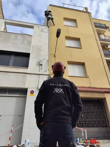 Un trabajador en un ascensor inspecciona la fachada de un edificio