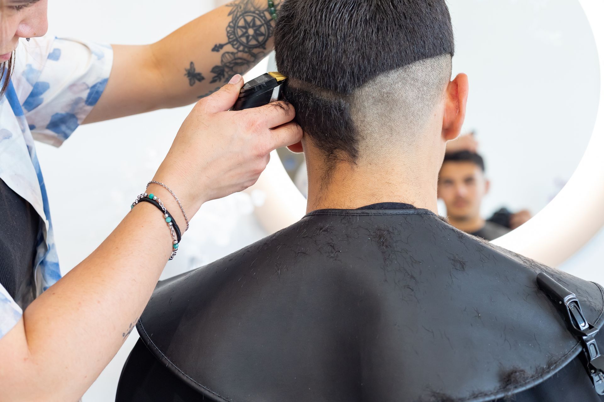 Une personne coupant les cheveux d'un homme.